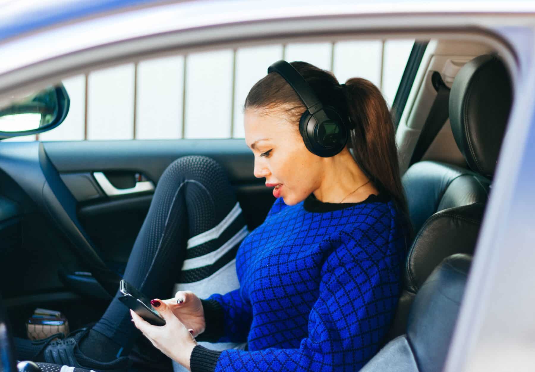 Frau mit Kopfhörern im Auto