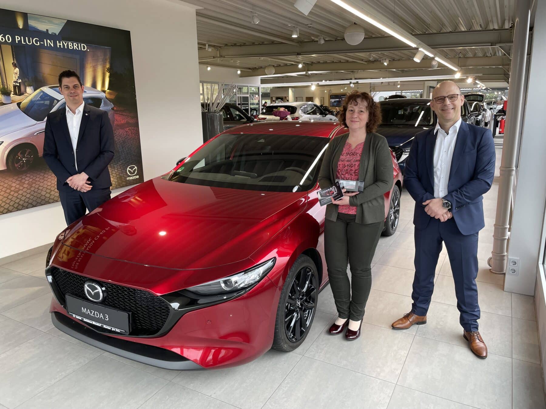 Felix Gebhart, Direktor Vertrieb Mazda Motors Deutschland GmbH (links) übergab gemeinsam mit Autohaus Blendorf Geschäftsführer Michael Busch den Jubiläums-Mazda an Ulrike Adam aus Herten